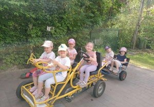Dzieci jadące jeździkiem.