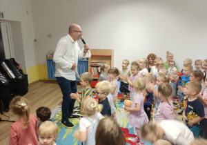 Dzieci tańczą przy śpiewającym panu
