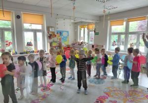 Dzieci pozują do zdjęcia z balonikami.