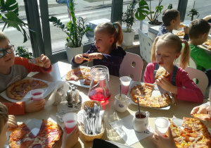 Dzieci jedzące pizzę