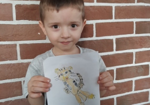Szymek prezentuje swój rysunek tygryska.